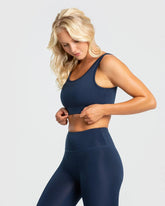 امرأة ترتدي أفضل حمالة صدر رياضية أساسية للسيدات باللون الأزرق الياقوتي وطماق باللون الأزرق الياقوتي.