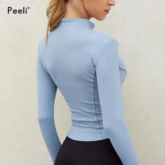 الجزء الخلفي من امرأة ترتدي سترة رياضية زرقاء بأكمام طويلة من Peeli بأكمام طويلة للنساء بسحاب للياقة البدنية واليوجا قميص شتوي دافئ للصالة الرياضية ملابس الجري معاطف الجري ملابس امرأة مصنوعة من البوليستر والياف لدنة. متوفر بأحجام مختلفة. العلامة التجارية: باور اب