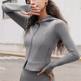 امرأة ترتدي سترة ذات قلنسوة رمادية اللون. لا طماق.