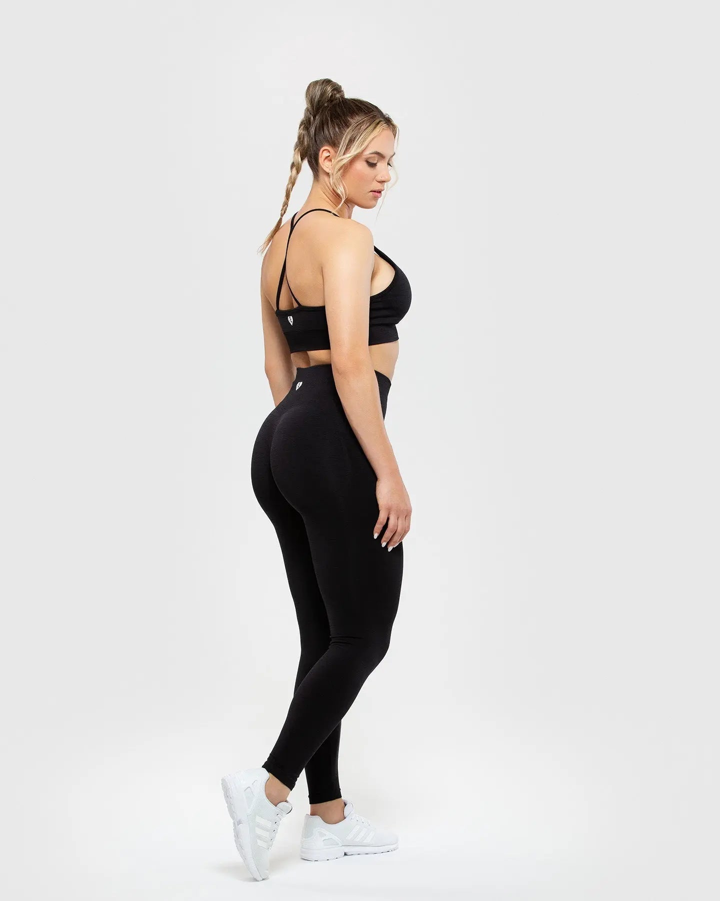 المنظر الأمامي لامرأة ترتدي ملابس Define Scrunch Seamless Leggings بلونه الأسود وبدون WOMEN'S BEST.