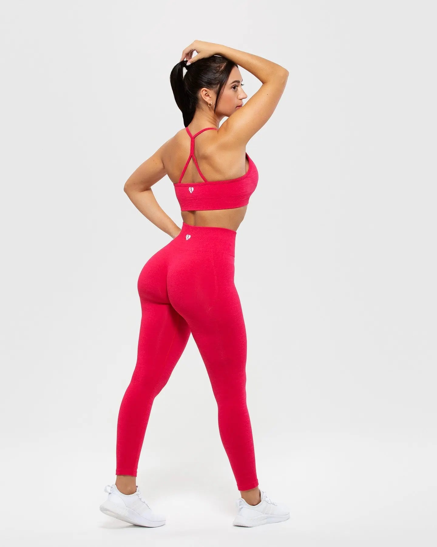 امرأة ترتدي حمالة صدر رياضية حمراء وسروالًا ضيقًا تعرض سروالها الضيق المرن Define Scrunch | مهارات Viva Magenta، الأفضل للنساء.