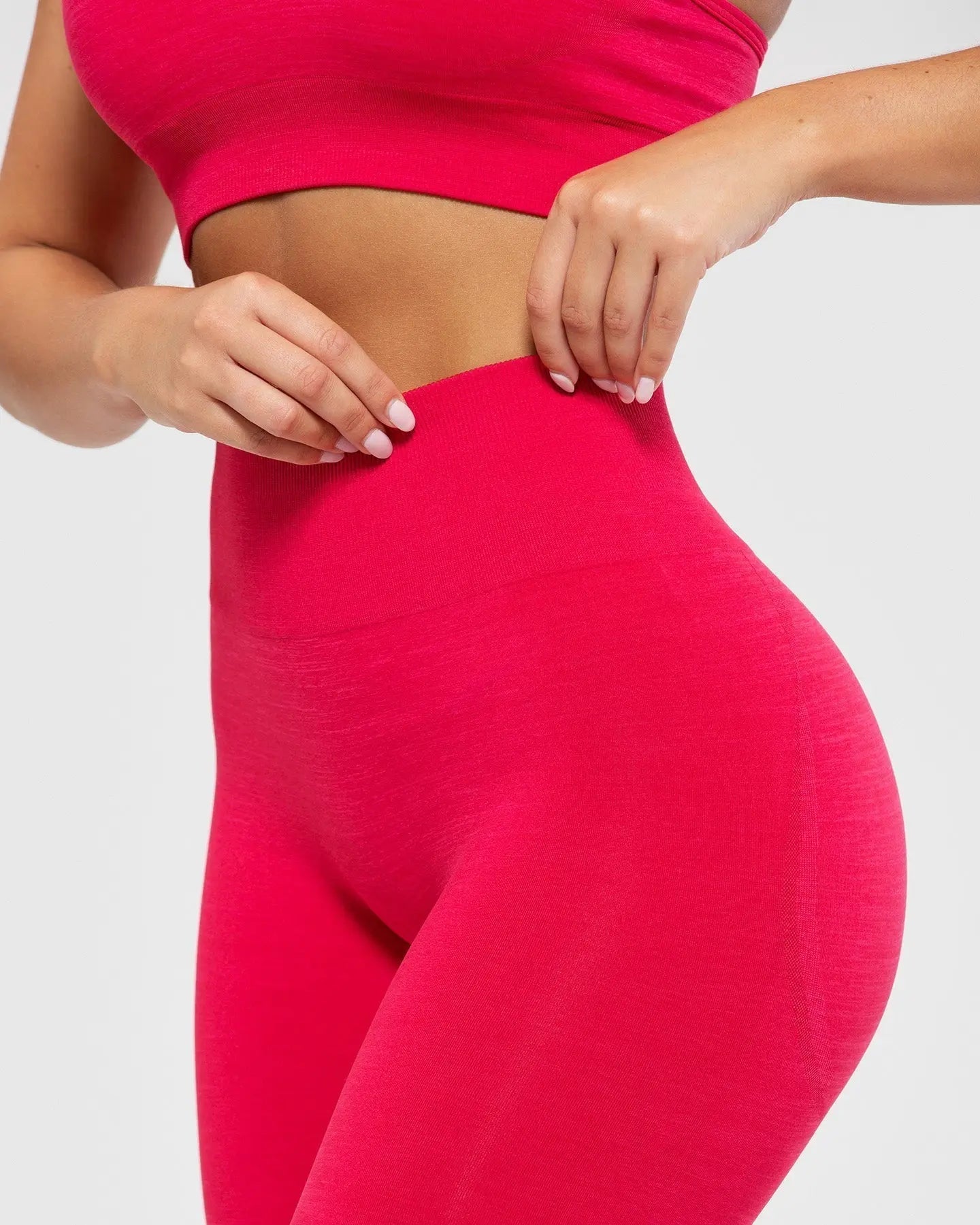 امرأة ترتدي بنطال ضيق بدون خياطة من ماركة Define Scrunch للسيدات | حمالة صدر رياضية وطماق Viva Magenta.