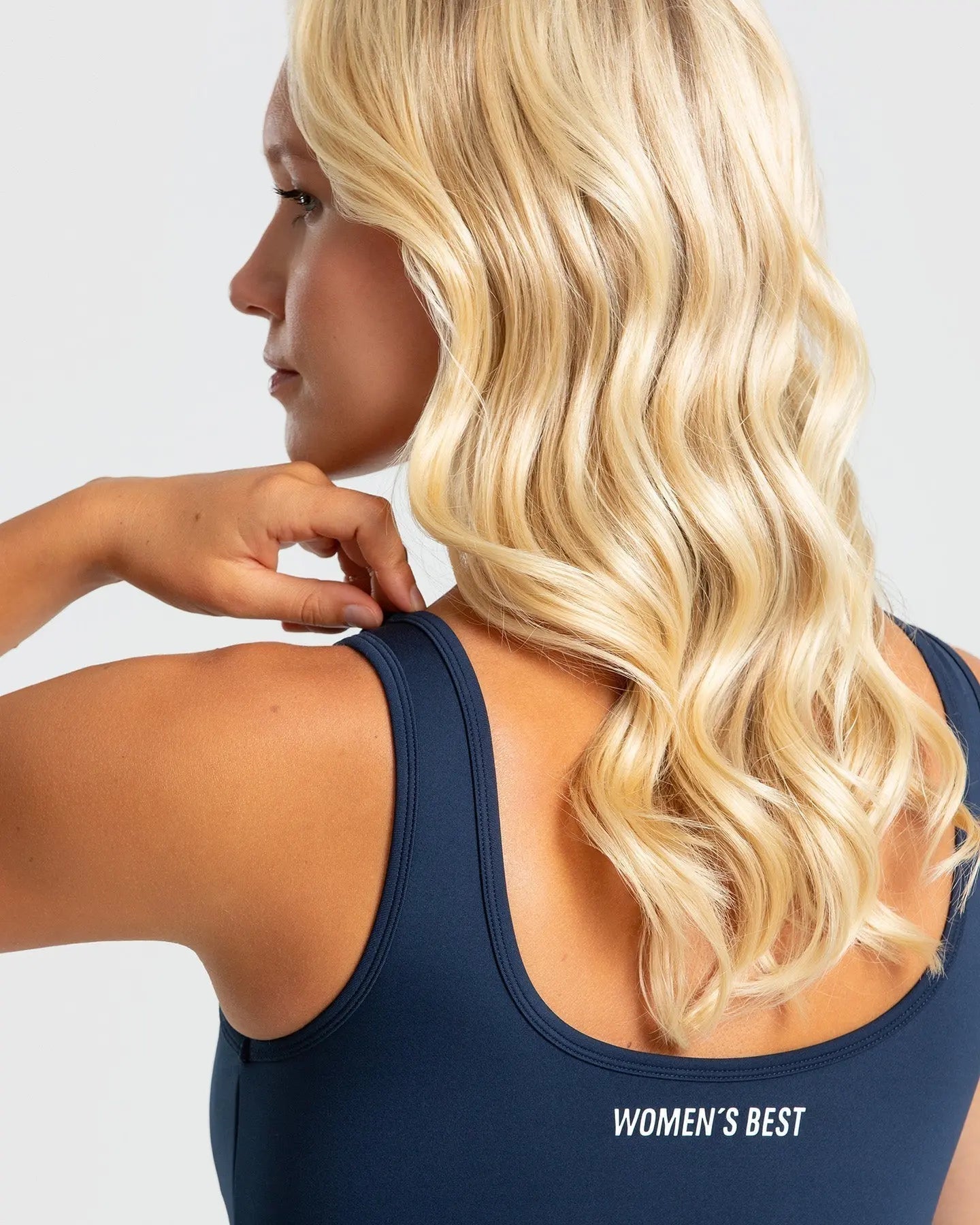 المنظر الخلفي لامرأة ترتدي أفضل حمالة صدر رياضية أساسية للنساء باللون الأزرق الياقوتي النابض بالحياة.