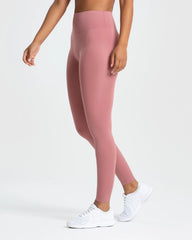 المنظر الخلفي لامرأة ترتدي أفضل السراويل الضيقة الأساسية للنساء باللون الوردي الترابي.