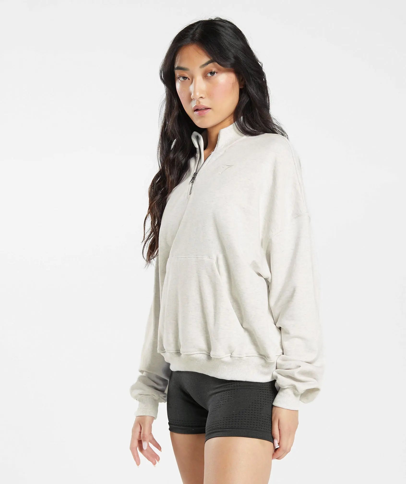 امرأة ترتدي Gymshark | United We Sweat Rest Day Sweats 1/2 كنزة صوفية وسروال أسود، مما يوفر الراحة القصوى.