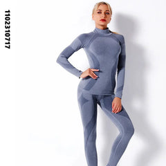 امرأة تقف لالتقاط صورة وهي ترتدي قميصًا رماديًا بأكمام طويلة وطماقًا، وتعرض ملابسها الرياضية مع ملابس داخلية حرارية شتوية نسائية للرياضة واللياقة البدنية والتزلج سريعة الجفاف الحرارية ذات الياقة المدورة النسائية مجموعة ملابس طويلة جونز محبوكة SK003.